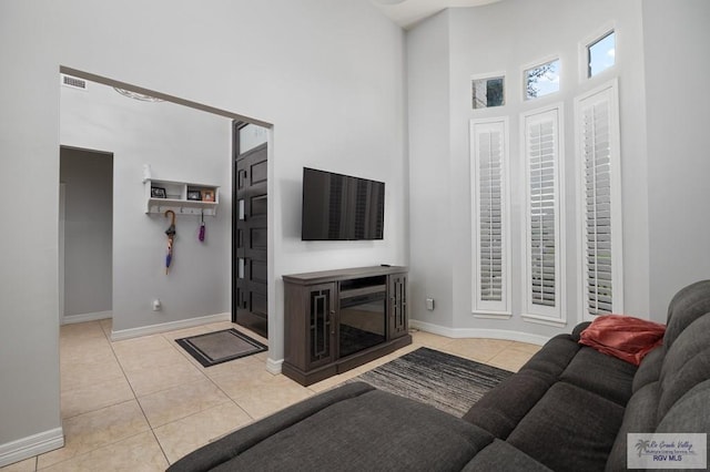 tiled living room with a towering ceiling