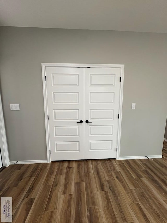 interior space featuring baseboards and wood finished floors