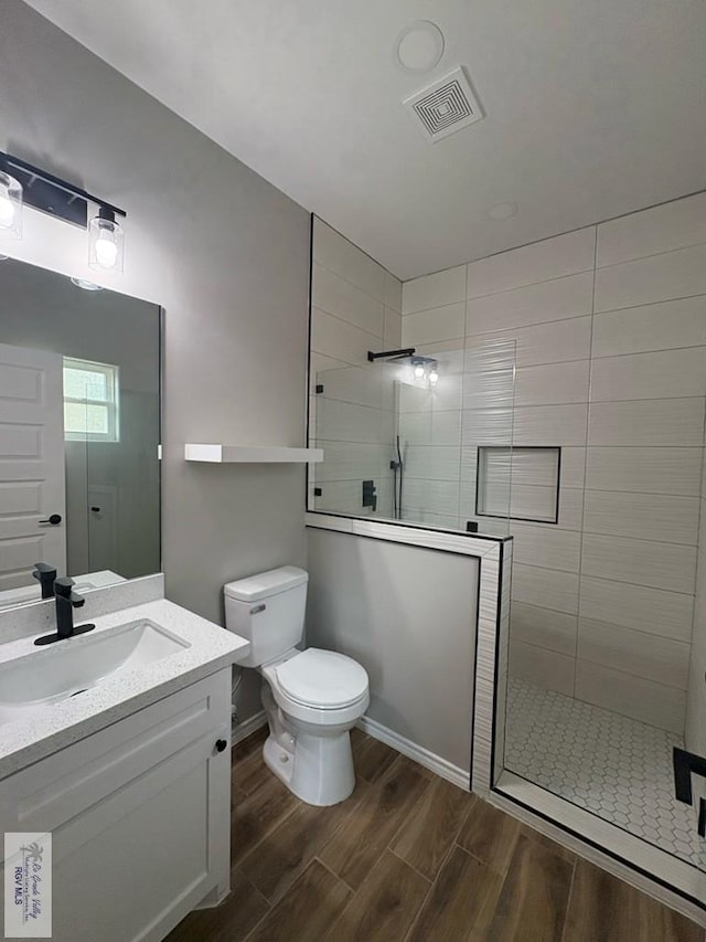 full bath featuring a walk in shower, visible vents, toilet, and wood finished floors