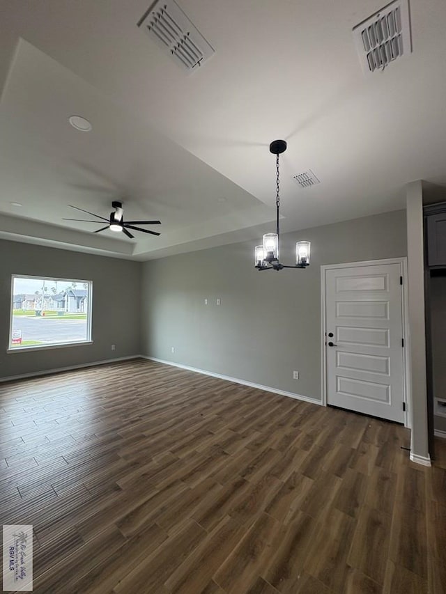 unfurnished room with baseboards, visible vents, dark wood finished floors, and ceiling fan with notable chandelier