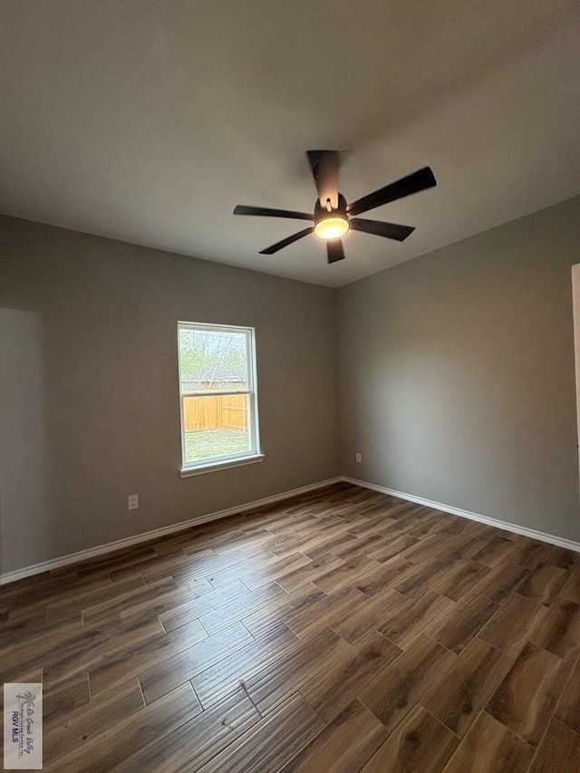 unfurnished room with a ceiling fan, dark wood finished floors, and baseboards