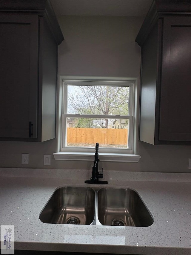 room details featuring a sink and light stone countertops