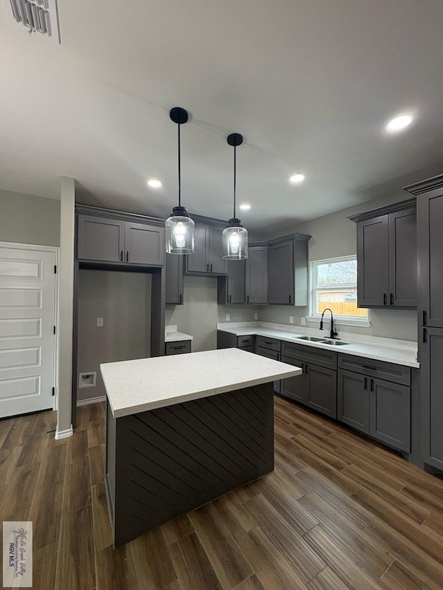 kitchen with dark wood-style flooring, gray cabinets, and a sink