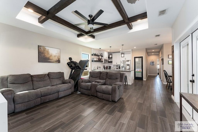 living area with dark wood-style floors, visible vents, coffered ceiling, and beamed ceiling