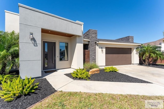 modern home with a garage, driveway, and stucco siding