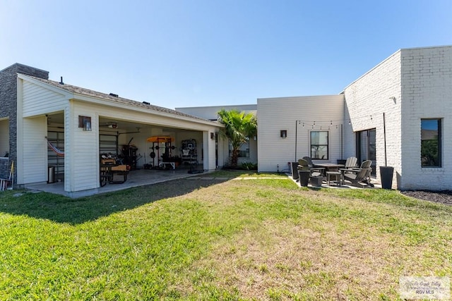 rear view of property featuring a patio area and a lawn