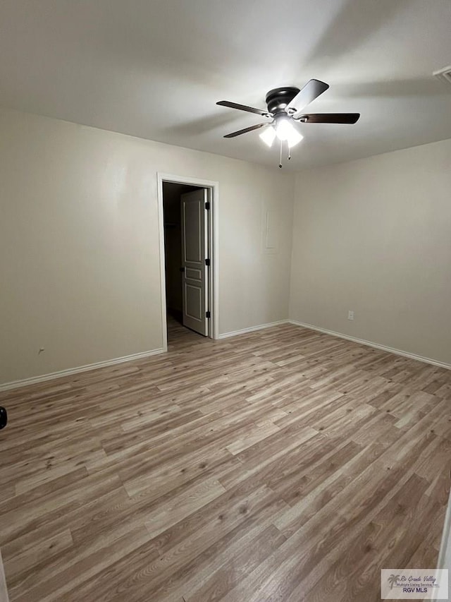 empty room with ceiling fan and light hardwood / wood-style flooring