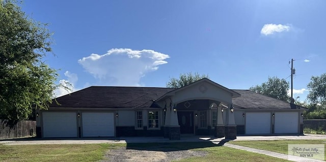 ranch-style home with a garage and a front lawn