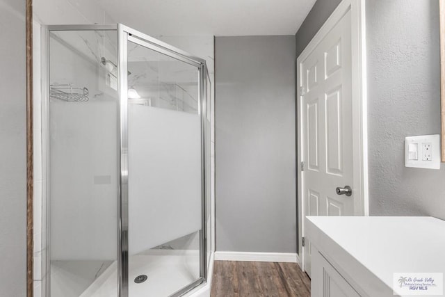 bathroom featuring hardwood / wood-style floors, vanity, and walk in shower