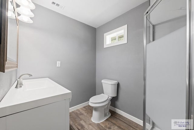 bathroom with toilet, vanity, and hardwood / wood-style flooring