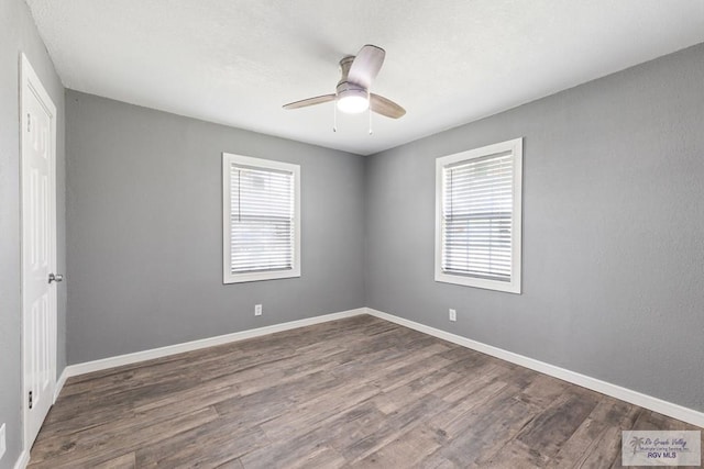 empty room featuring ceiling fan and dark hardwood / wood-style flooring