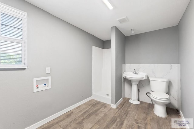 bathroom with a shower, hardwood / wood-style flooring, toilet, and sink