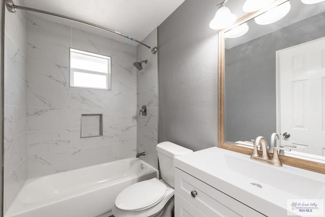 full bathroom featuring toilet, vanity, and tiled shower / bath