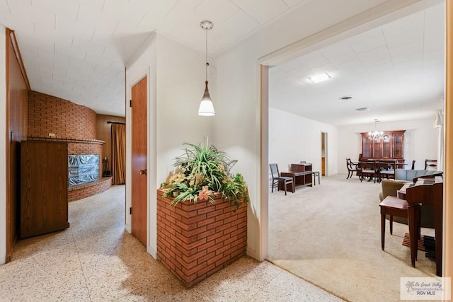 hall with an inviting chandelier