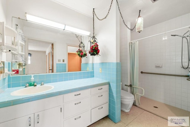 bathroom featuring vanity, curtained shower, toilet, and tile walls