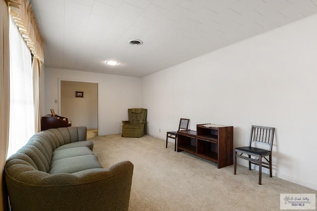 living area featuring light carpet