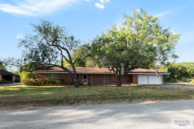 ranch-style house featuring a garage and a front yard