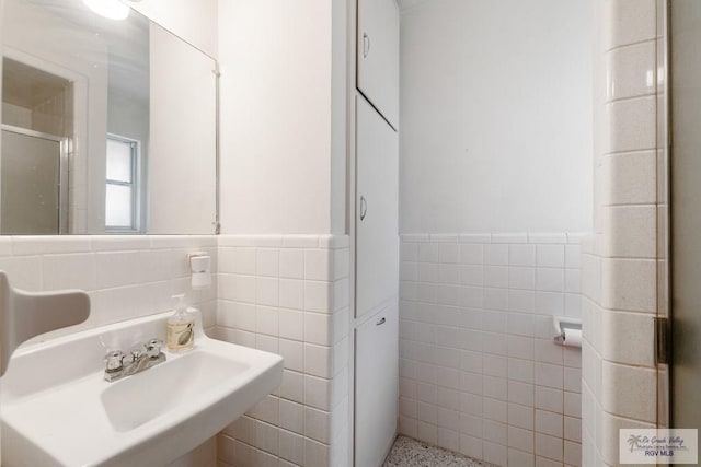 bathroom with sink and tile walls