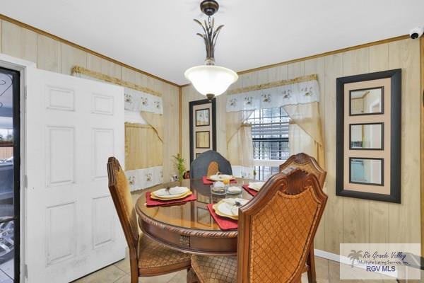 dining space featuring light tile patterned floors and crown molding