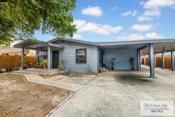 view of front facade with driveway, fence, and an attached carport