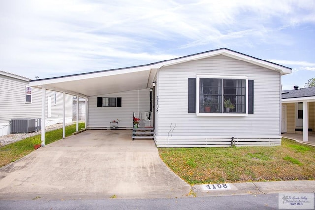 view of front facade featuring central air condition unit, driveway, a carport, and a front yard