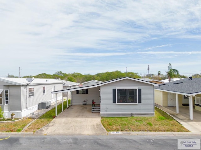 manufactured / mobile home with central AC unit and a front lawn