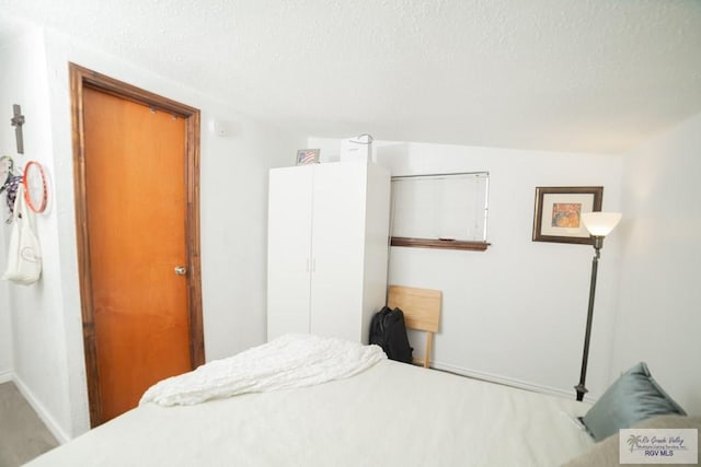 bedroom featuring baseboards and a textured ceiling