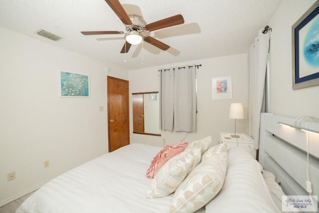 bedroom featuring visible vents, ceiling fan, and a textured ceiling