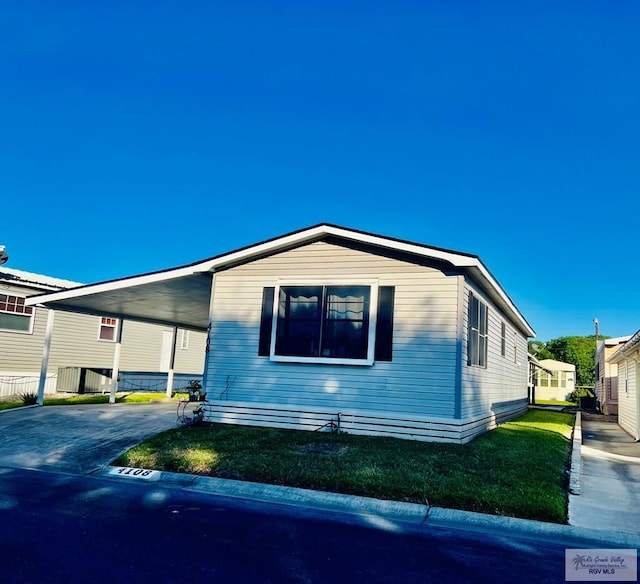 view of side of property with an attached carport and concrete driveway