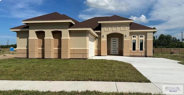 view of front of home featuring a garage, driveway, a front lawn, and stucco siding