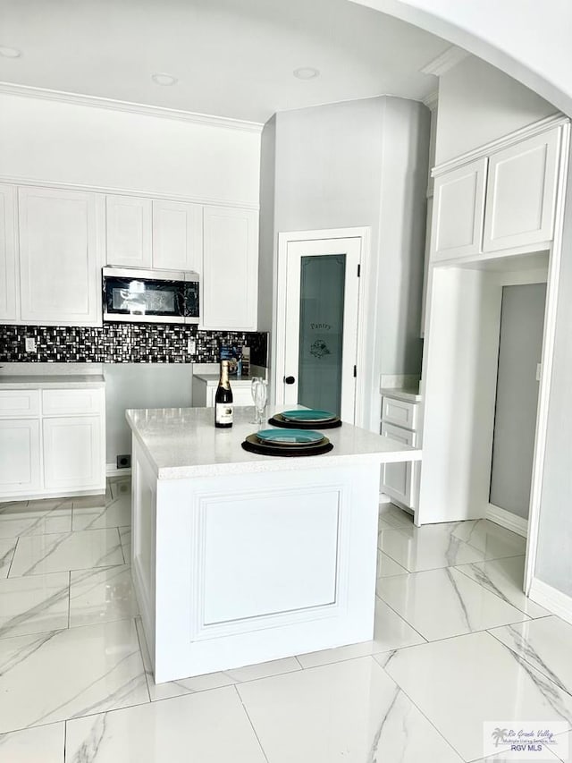 kitchen featuring a center island, white cabinets, and stainless steel microwave