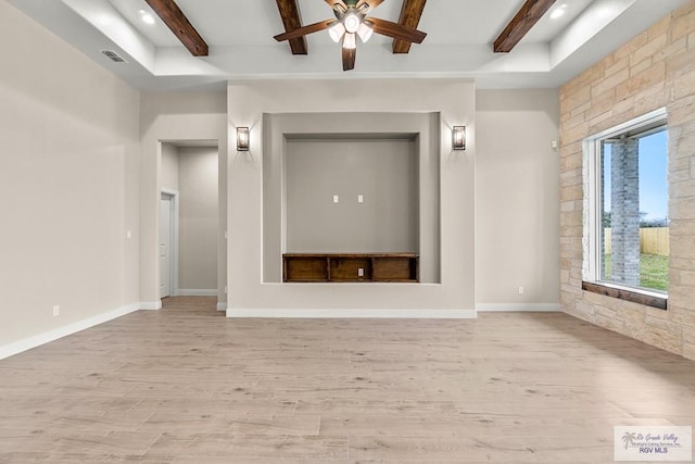 unfurnished room featuring baseboards, visible vents, beamed ceiling, and light wood finished floors