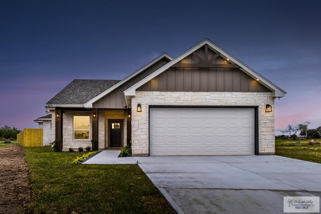 view of front of home featuring driveway, roof with shingles, an attached garage, a front lawn, and board and batten siding