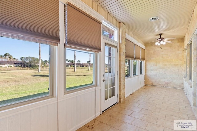 unfurnished sunroom featuring wood ceiling, visible vents, and a ceiling fan