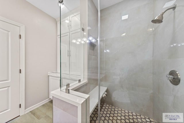 bathroom with baseboards and tiled shower