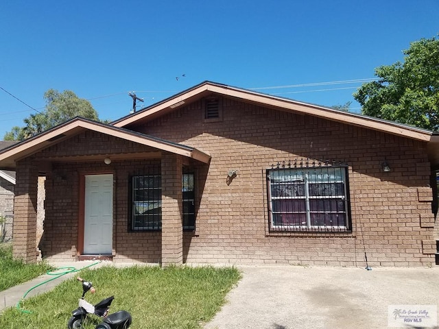 single story home featuring brick siding