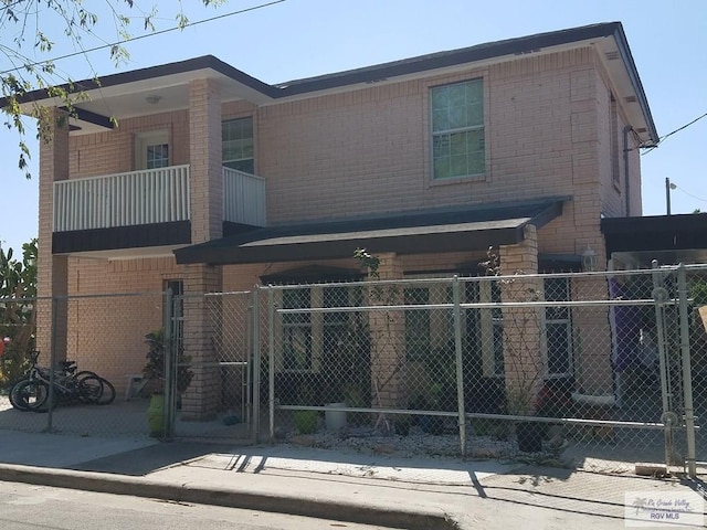 view of front of house featuring fence and brick siding