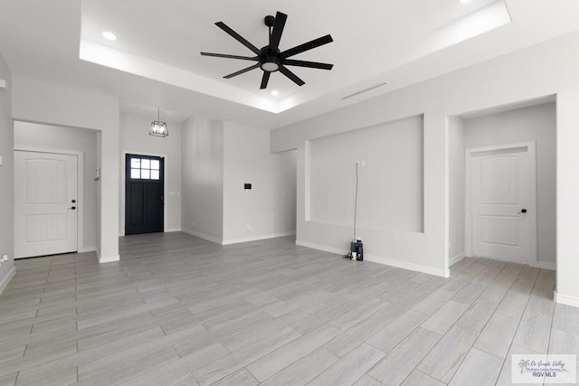 9484 S Queen Palm, Los Fresnos, TX 78566 - unfurnished living room with a raised ceiling, a ceiling fan, light wood-style flooring, and recessed lighting