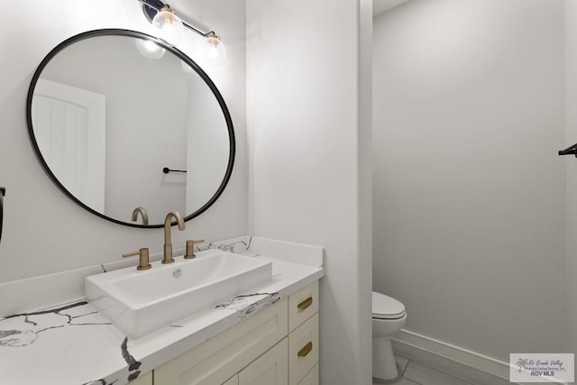 bathroom featuring tile patterned floors, vanity, and toilet