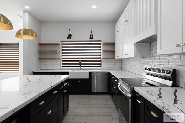 kitchen with a healthy amount of sunlight, white cabinetry, stainless steel appliances, and decorative light fixtures