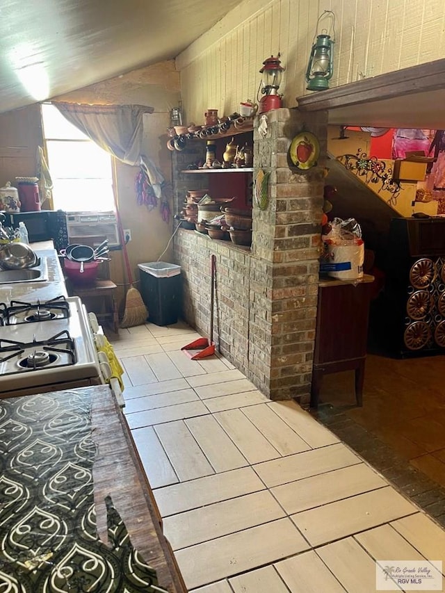23362 Fm 506, Santa Rosa, TX 78593 - kitchen with tile patterned floors, vaulted ceiling, wooden walls, and gas range