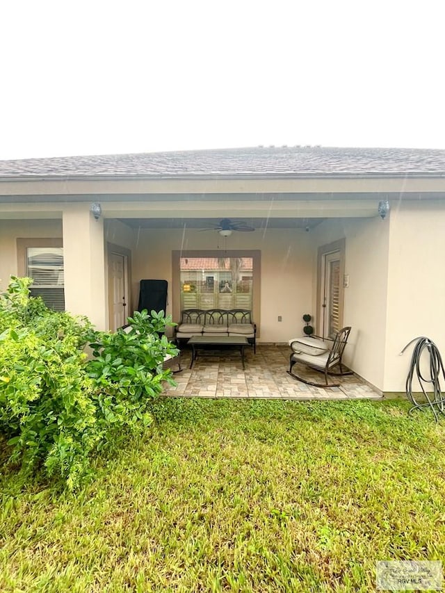 back of property featuring a patio, ceiling fan, and a lawn