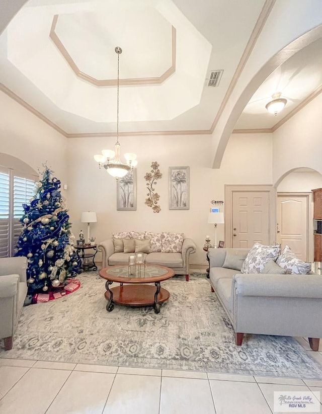 living room with tile patterned flooring, a raised ceiling, an inviting chandelier, and crown molding