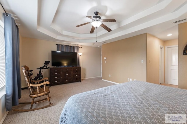 bedroom with ceiling fan, a raised ceiling, and light carpet