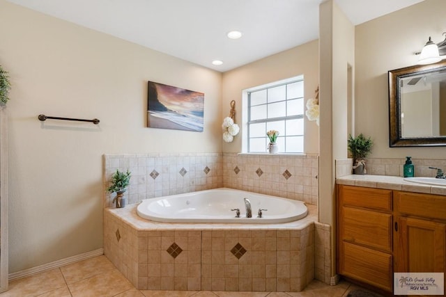 bathroom with tile patterned flooring, tiled tub, and vanity