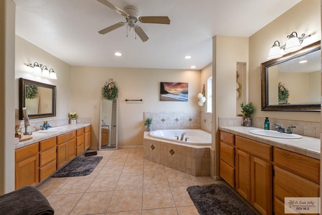 bathroom featuring a relaxing tiled tub, vanity, tile patterned floors, and ceiling fan