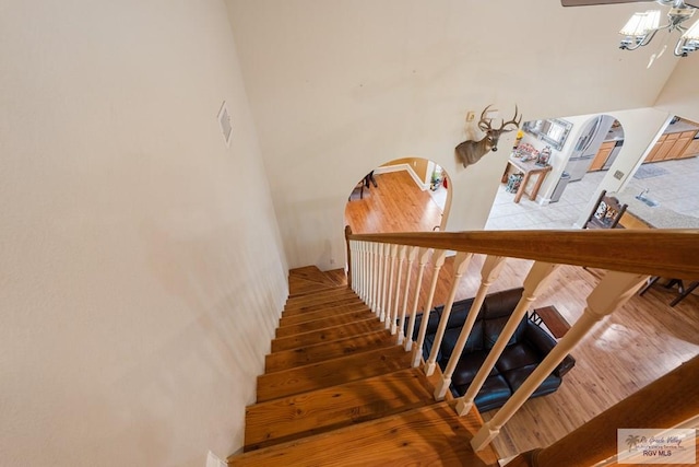 stairway with ceiling fan and wood-type flooring