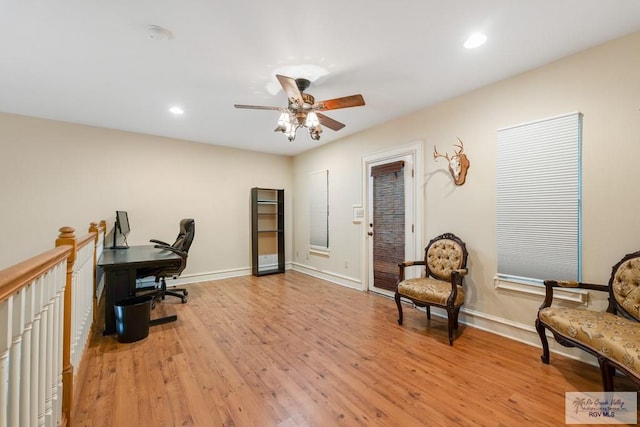 office with ceiling fan and light hardwood / wood-style flooring