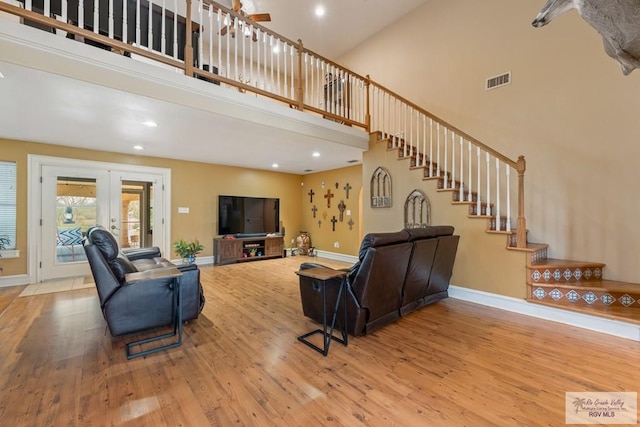 living room with french doors, wood-type flooring, and a high ceiling