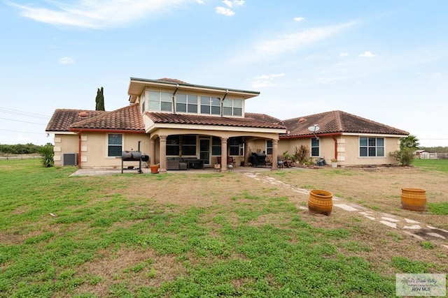 back of property with cooling unit, a lawn, and a patio